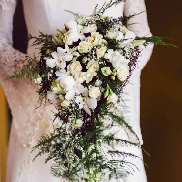 Grande gerbe funéraire élégante avec des roses blanches, des hortensias verts, des gerberas roses et un feuillage raffiné, conçue dans le Pays de Gex